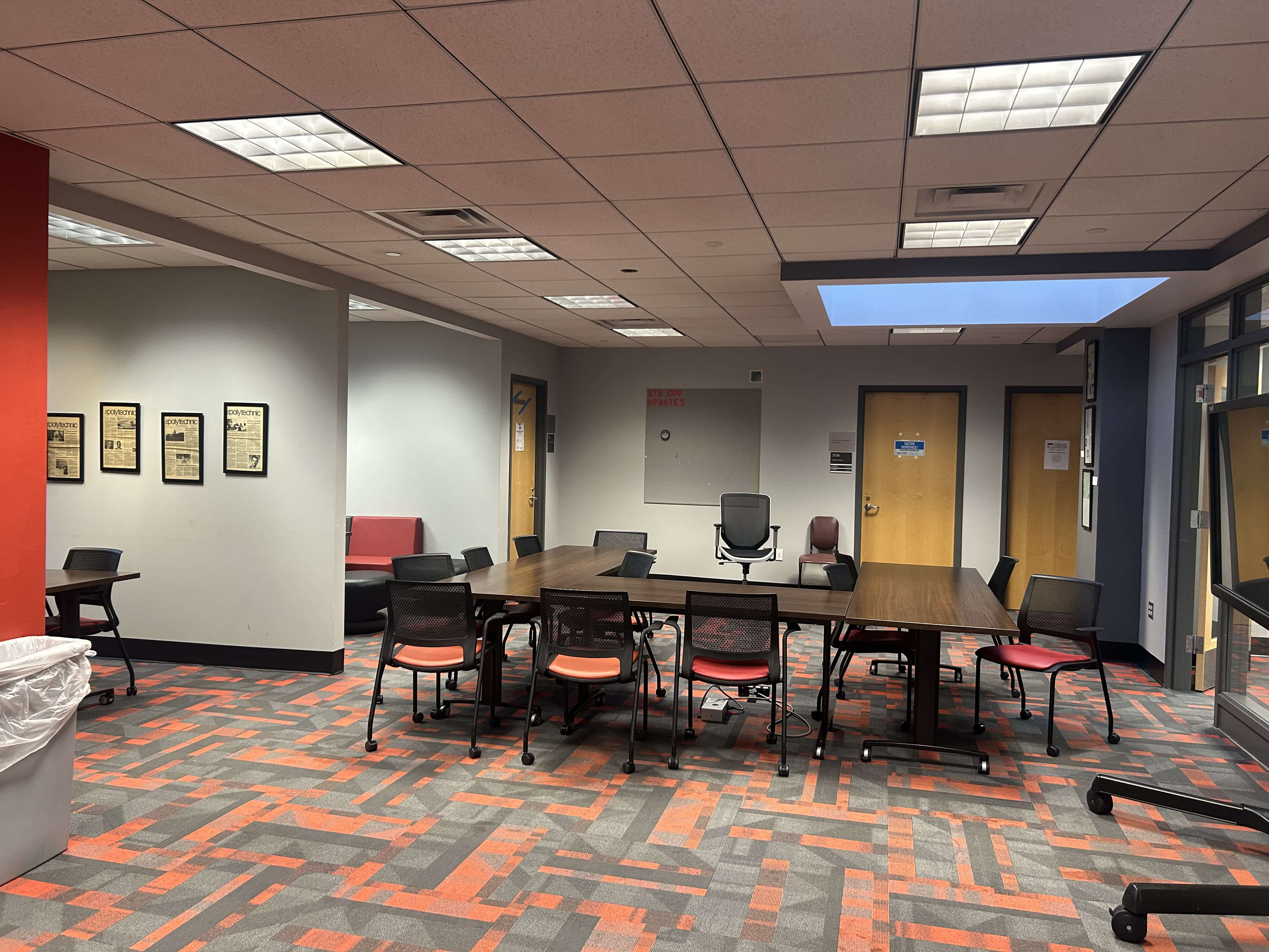 SGS west side, with several long tables and chairs. In the back there are doors to offices.